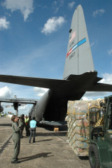 Pallet of humanitarian aid being loaded onto a military cargo plane.